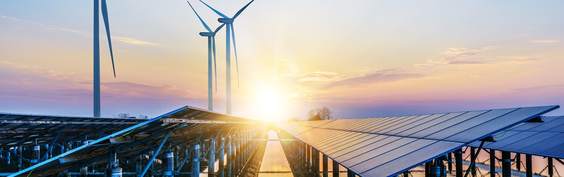 Erneuerbare Energien: Windkraftanlagen und Solaranlagen im Sonnenuntergang